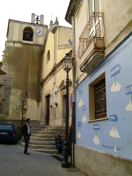 viaggio in risciò -
piazza della chiesa, col murales dei paesi d'origine dei nuovi arrivati